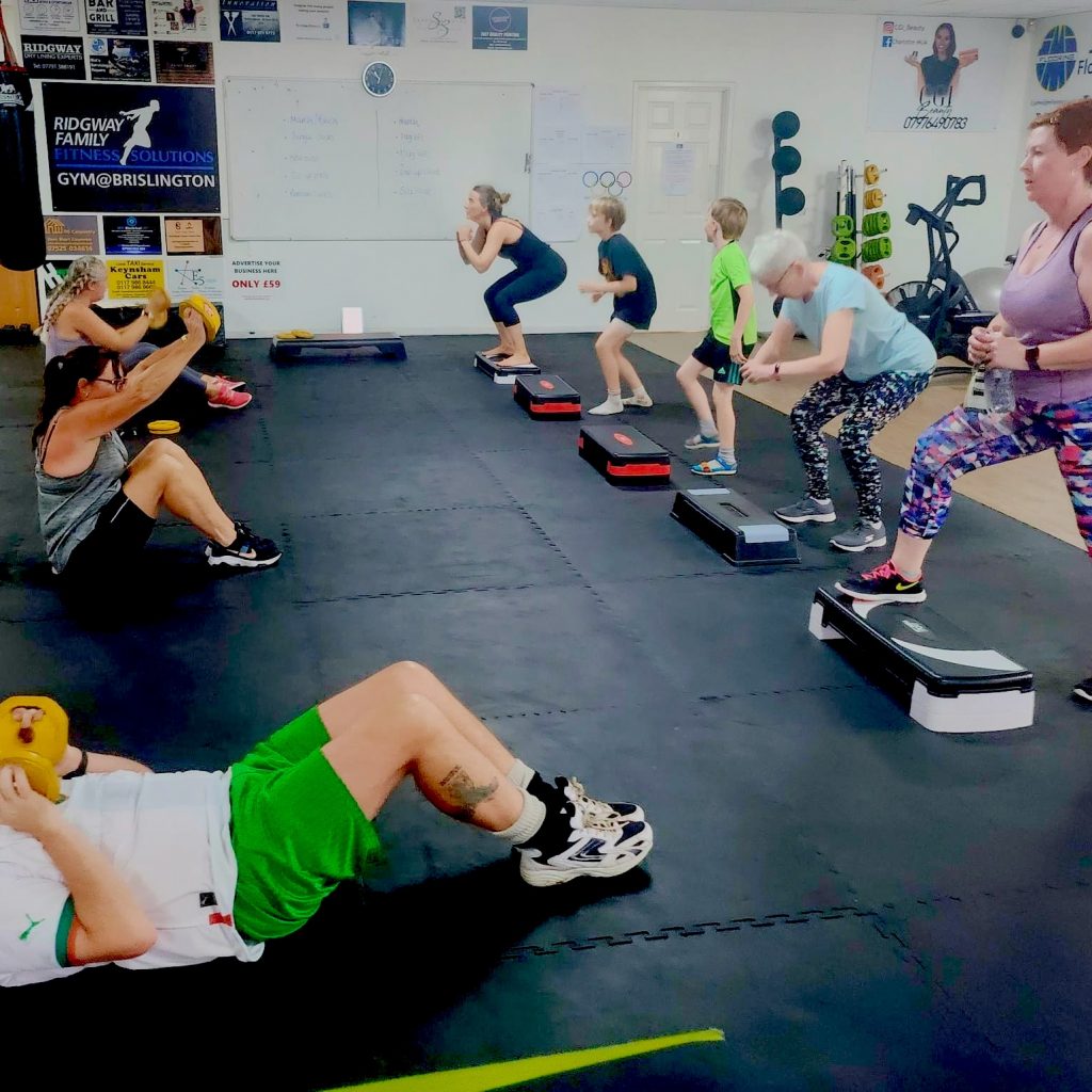 Image of an exercise class with various cardio exercises being executed.
